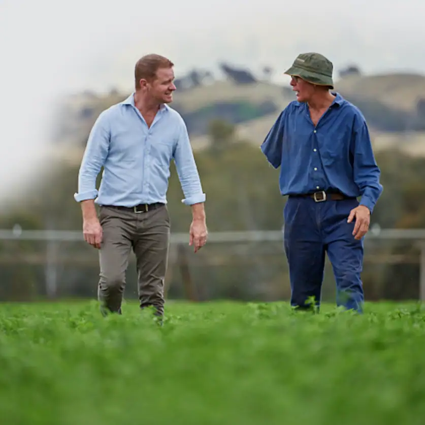 Relaxed conversation between two men outdoors, representing a positive work culture.